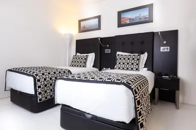 a bedroom with two beds with black and white sheets at Faro Boutique Hotel in Faro