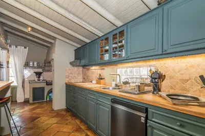 a large kitchen with blue cabinets and a sink at FLH Belaventura Villa in Boliqueime