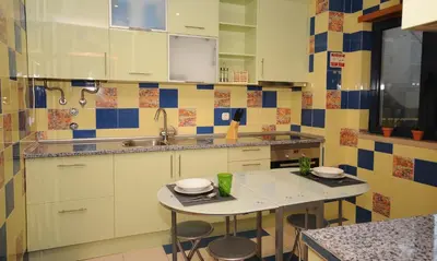 a kitchen with a sink and a table with stools at AlgarveFlat in Albufeira