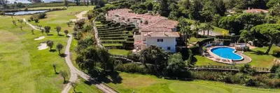 a large swimming pool with lounge chairs and umbrellas at Formosa Villas in Quinta do Lago