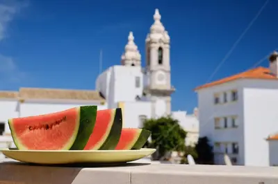 a plate with a slice of watermelon on a table at Casa da Avó in Faro