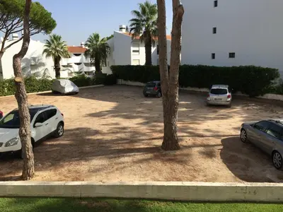 a parking lot with cars parked in front of a building at Apartment in Algarve,Vilamoura in Vilamoura