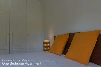 a bedroom with a bed with two orange pillows at Akisol Vilamoura Sun III in Vilamoura