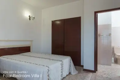 a bedroom with a bed and a bathroom with a toilet at Akivillas Quarteira Rose in Quarteira