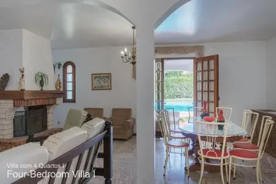 a living room and a dining room with a table at Akivillas Quarteira Rose in Quarteira