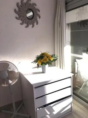 a white dresser with a vase of flowers on it at Albufeira Portugal Maria appt in Albufeira
