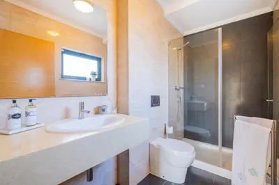 a bathroom with a sink and a toilet and a shower at Villas Novochoro - Large Garden- Heatable Pool by DreamvillasAlbufeira in Albufeira