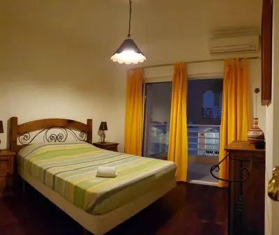 a bedroom with a bed and a window with yellow curtains at Marina Vilamoura Apartment in Vilamoura