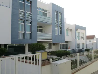 a building with a white fence in front of it at Bay View Apartment Albufeira in Albufeira