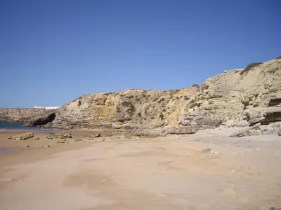 a sandy beach next to a cliff at Bay View Apartment Albufeira in Albufeira