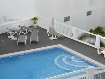 a large pool on a balcony with chairs and a table at Bay View Apartment Albufeira in Albufeira