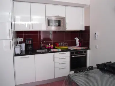 a kitchen with white cabinets and a microwave at Bay View Apartment Albufeira in Albufeira