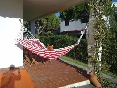 a hammock on a patio with chairs and a house at Algarve Apartment Falésia in Albufeira