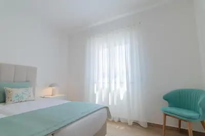 a bedroom with a bed and a blue chair at Apartments Salomé in Albufeira