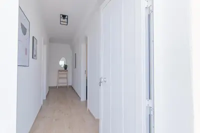 a hallway with white walls and a wooden floor at Apartments Salomé in Albufeira
