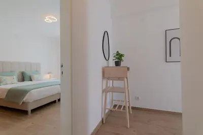 a bedroom with a bed and a mirror and a stool at Apartments Salomé in Albufeira