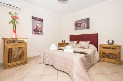 a kitchen with wooden cabinets and a microwave at Villa Anita in Quarteira