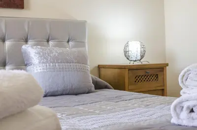 a blue bed with a blue headboard and two chairs at Villa Anita in Quarteira