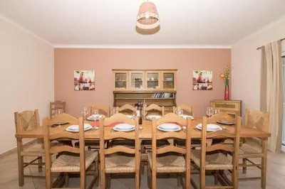 a dining room with a wooden table and chairs at Villa Anita in Quarteira