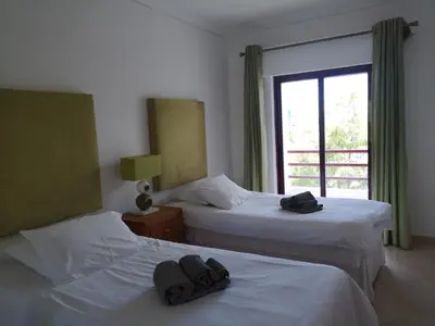 two beds in a hotel room with towels on them at Mare Viva Beach Apartment in Quarteira