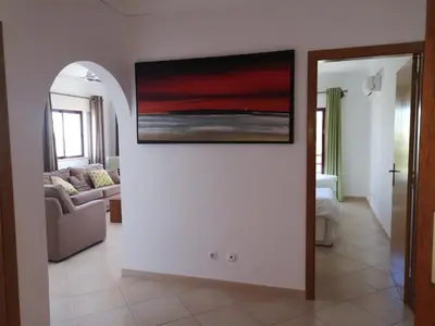 a living room with a painting on the wall at Mare Viva Beach Apartment in Quarteira