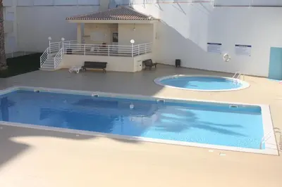 a large swimming pool in front of a building at Albufeira Lovely new Apartment W/ Pool in Albufeira