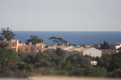 a town on a hill with the ocean in the background at Albufeira Lovely new Apartment W/ Pool in Albufeira