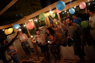 a group of people standing in a party with balloons at Casa da Madalena Backpackers Hostel in Faro