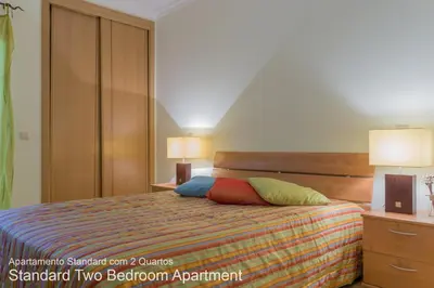 a bedroom with a bed with two night stands and two lamps at Akisol Vilamoura Nature in Vilamoura