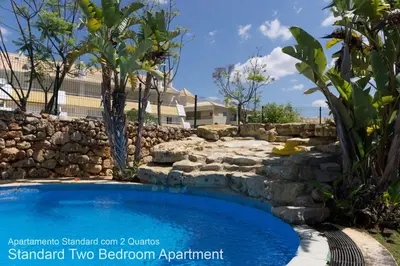 a swimming pool in a yard with a stone wall at Akisol Vilamoura Nature in Vilamoura