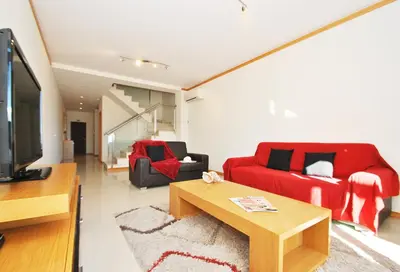 a living room with a red couch and a table at Townhouse Mar 1 by Algarve Vacation in Albufeira