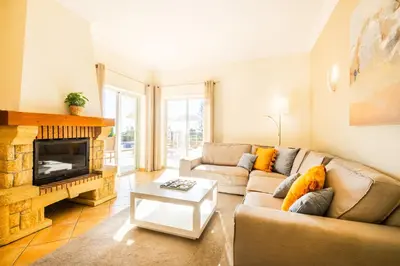 a living room with a couch and a fireplace at Villa Florença by Algarve Vacation in Albufeira