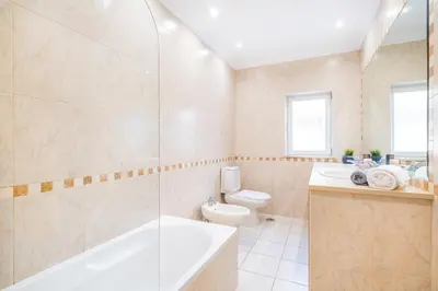 a bathroom with a tub and a toilet and a sink at Villa Florença by Algarve Vacation in Albufeira