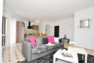 a living room with a gray couch and pink pillows at Apartment Capri by Algarve Vacation in Albufeira