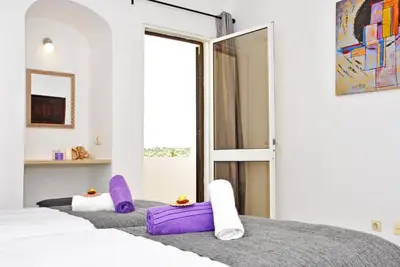 a bedroom with two beds with purple and white towels at Apartment Capri by Algarve Vacation in Albufeira