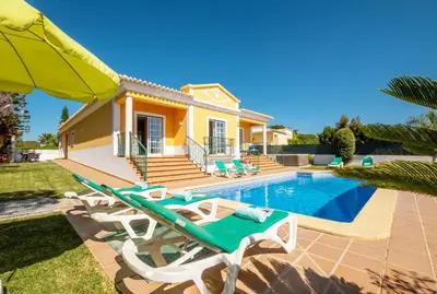a villa with a swimming pool and a house at Villa Alegria by Algarve Vacation in Albufeira