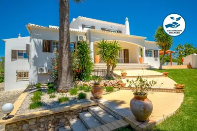 a house with a palm tree in front of it at Villa Valentina by Algarve Vacation in Almancil
