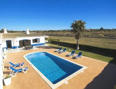 a swimming pool with lounge chairs and a house at Villa Sardenha by Algarve Vacation in Guia