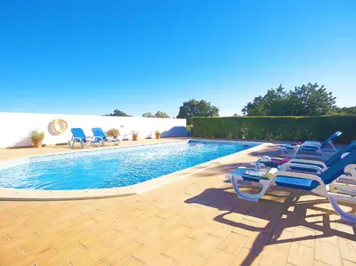 a swimming pool with lounge chairs next to a swimming pool at Villa Martinica by Algarve Vacation in Guia