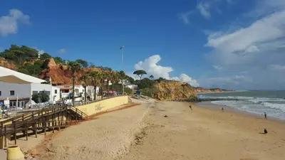 a beach with people on the sand and the ocean at Olhos do Mar in Albufeira