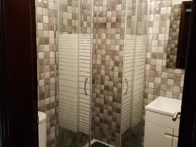 a bathroom with a shower with a toilet and a sink at Almancil Hostel in Almancil
