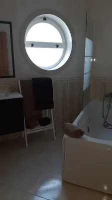 a bathroom with a tub and a large window at Edifice Ibérico in Albufeira