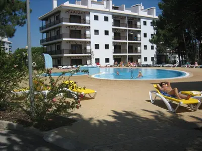 a woman sitting in a chair in a swimming pool at Apartamento Falesia 6 B in Albufeira