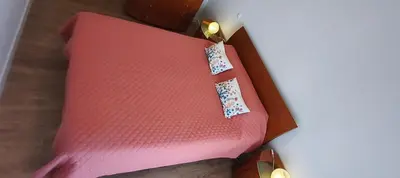 a pink bed with a tie on top of it at Rooms_Heart Apartment in Faro