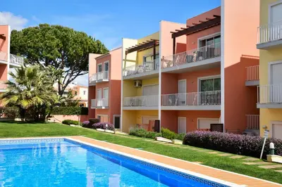a swimming pool in front of two apartment buildings at Old Village Prestige 101 in Vilamoura