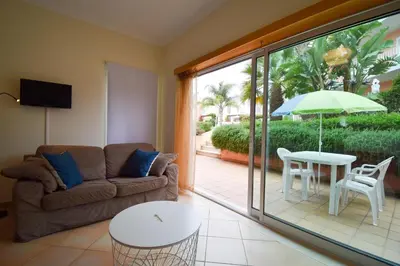a living room with a couch and a table with an umbrella at Old Village Prestige 101 in Vilamoura