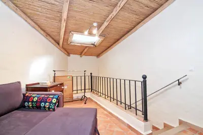 a living room with a couch and a wooden ceiling at Casinha Antiga in Boliqueime