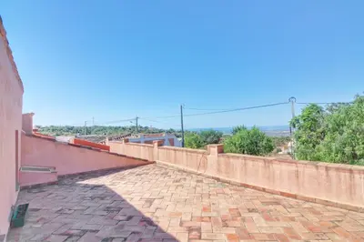 a brick wall next to a brick sidewalk at Casinha Antiga in Boliqueime