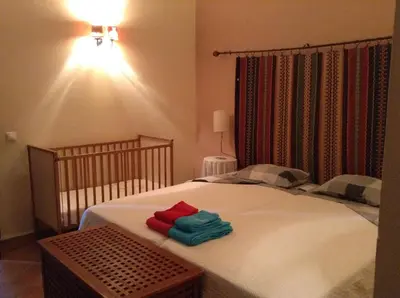a bedroom with a bed with two towels on it at Casinha Antiga in Boliqueime