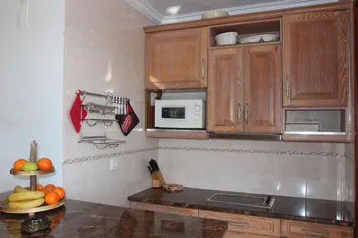 a kitchen with wooden cabinets and fruits on a counter at Beach Center 2 - 300m beach in Albufeira